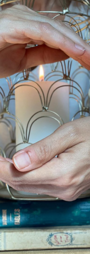 Au cœur de l’énergie Deux mains entourent une bougie allumée, créant une ambiance chaleureuse.