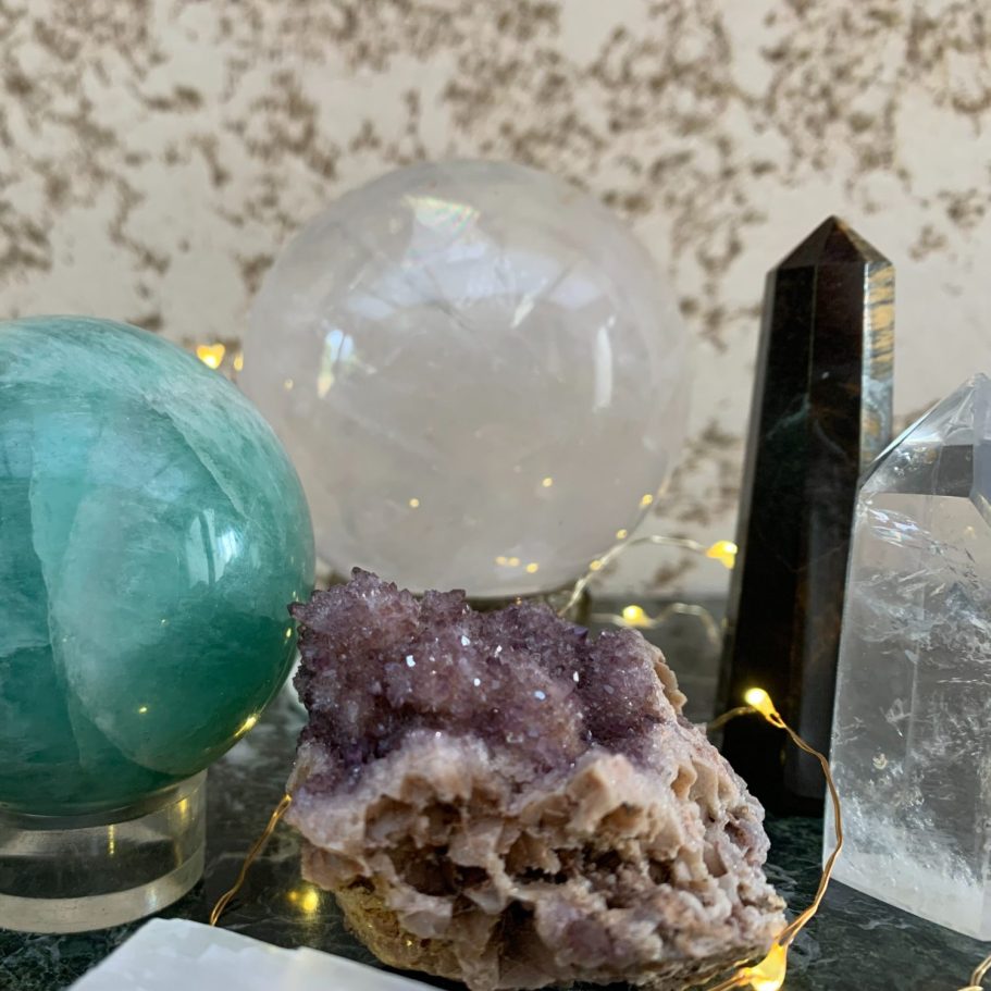 Alliance sacrée des pierres énergétiques Rassemblement de cristaux colorés : quartz clair, fluorite verte et améthyste, avec lumières.